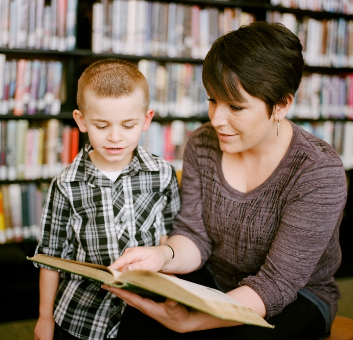 Child with teacher reading a book