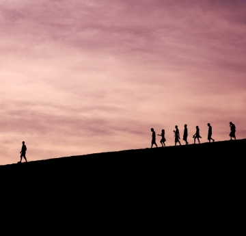 Silhouettes of a group following a leader